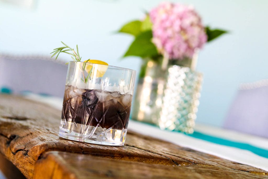 Photo of blackberry and rosemary sour in a cocktail glass.